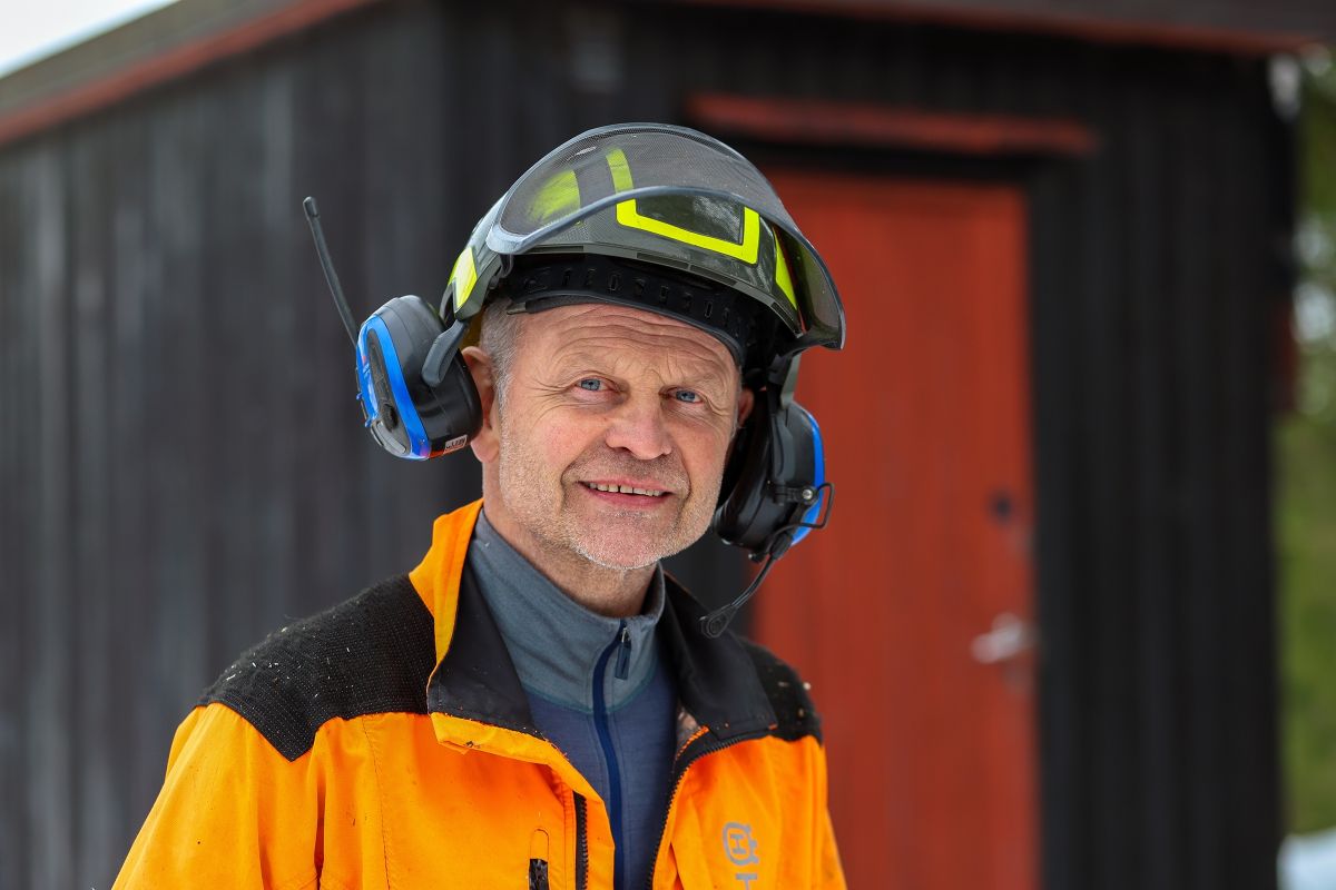 Henning Røsholt med hjelm og verneutstyr ved brakka i skogen ved Steinsholt