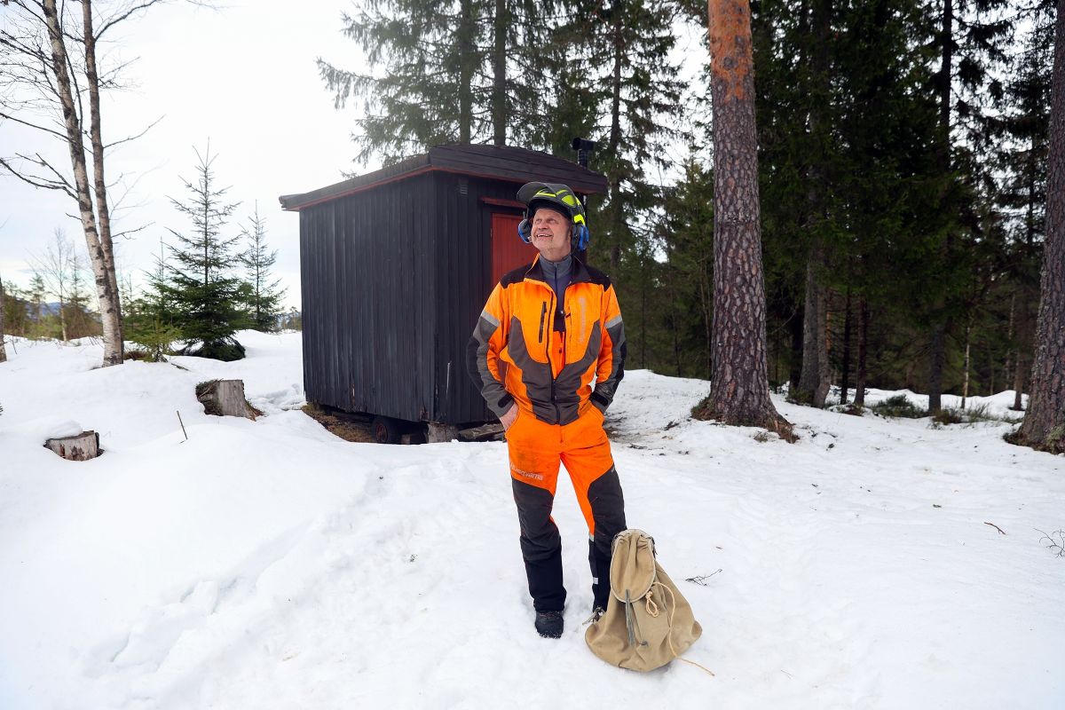 Henning Røsholt med hjelm og verneutstyr ved brakka i skogen ved Steinsholt